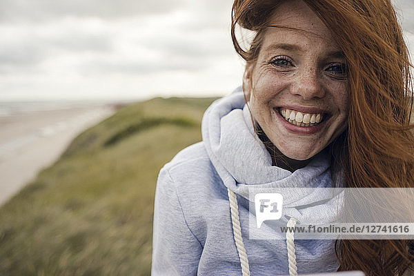 Redheaded woman enjoying fresh air at the beach