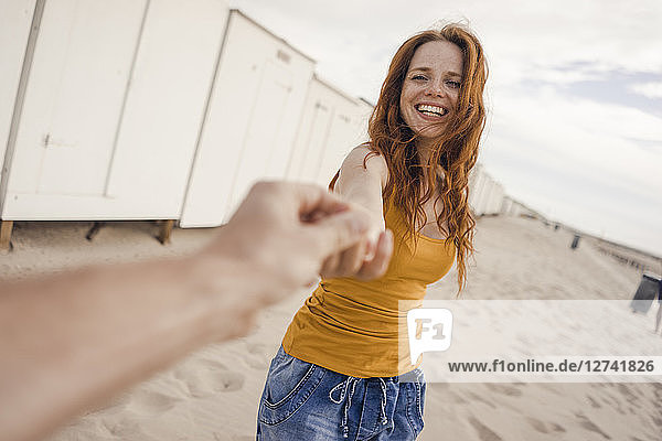 Smiling woman reaching out to man's hand