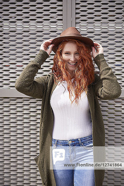 Portrait of smiling redheaded woman with brown hat
