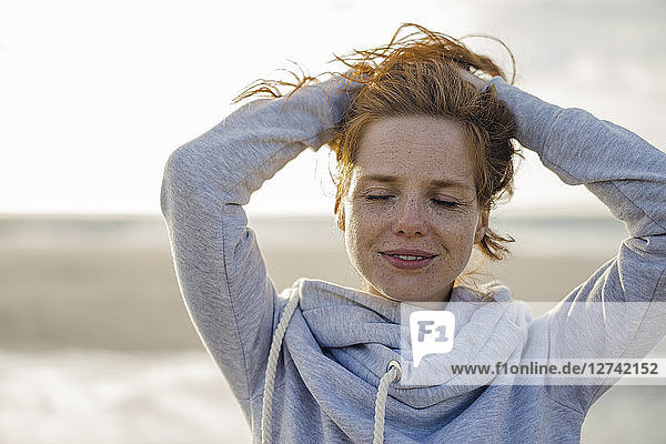 Redheaded woman enjoying fresh air at the beach