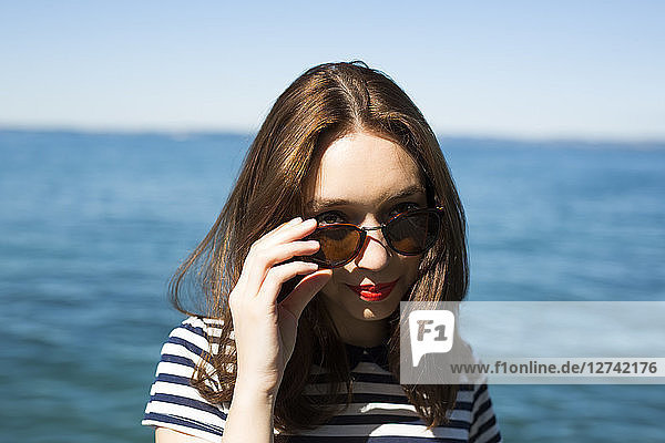 Italy  Lake Garda  portrait of smiling young woman with sunglasses