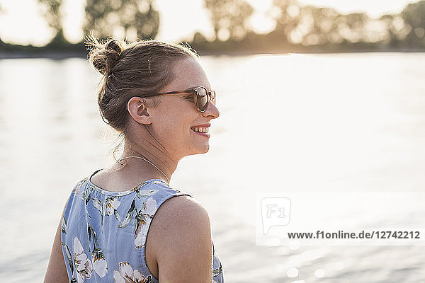 Smiling young woman at the riverbank