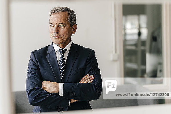 Portrait of mature businessman with arms crossed in his office