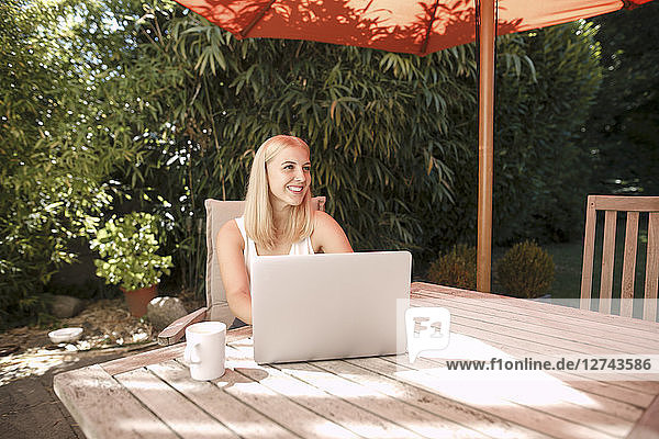 Young woman using laptop in garden