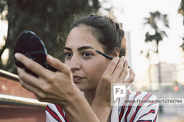 Portrait of woman applying mascara