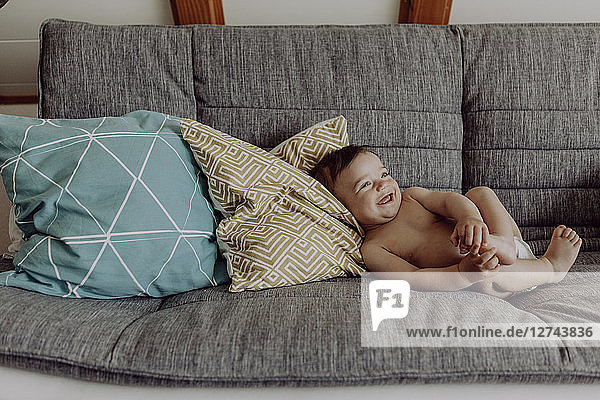 Laughing baby lying on couch