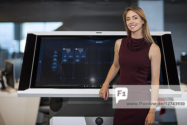 Businesswoman standing in front of communication screen