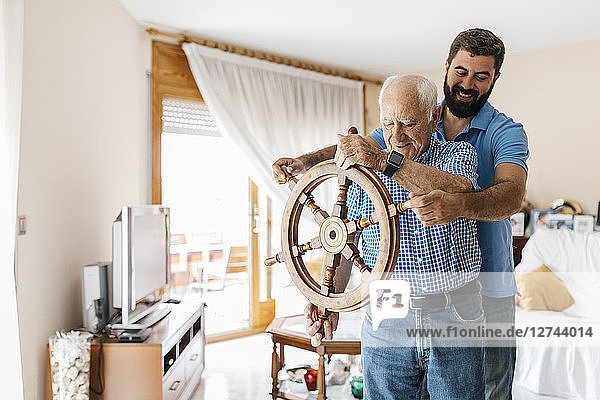 Grandfather and adult son with helm in the living room