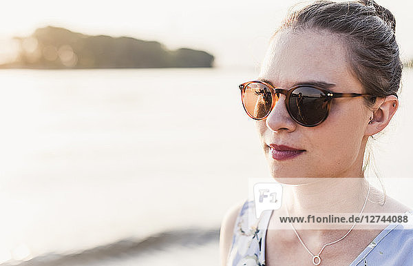 Young woman wearing sunglasses at the riverbank