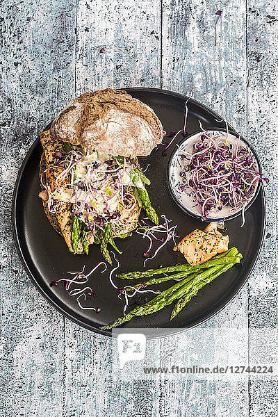 Salmon burger with green asparagus and red cress on plate