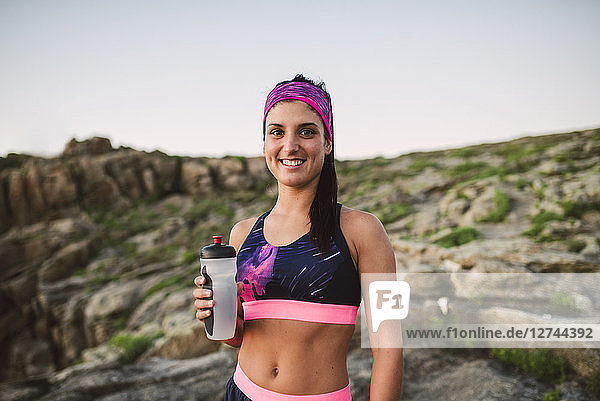 Portrait of an athlete woman drinking water outdoors