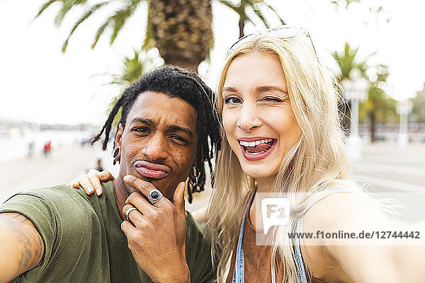 Portrait of multicultural young couple taking selfie