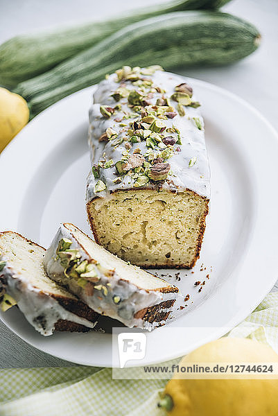 Lemon zucchini cake with lemon icing and pistachio topping