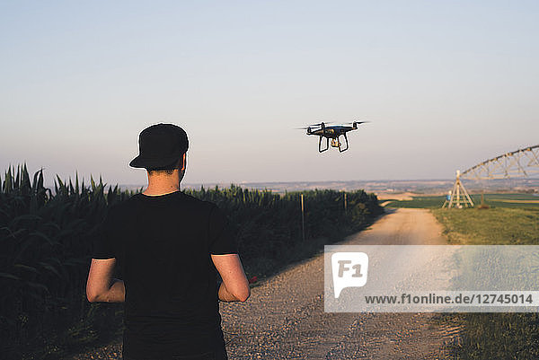 Man flying drone in a field