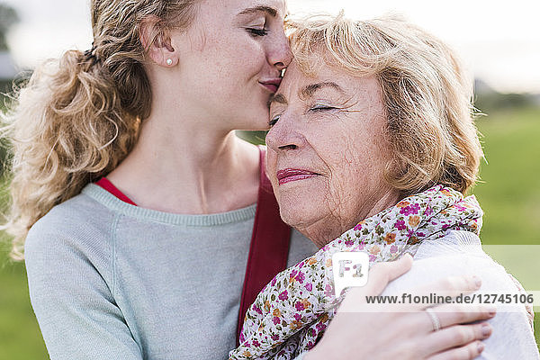 Granddaughter kissing her grandmother