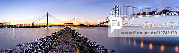 UK  Scotland  Fife  Edinburgh  Firth of Forth estuary  Panorama view from South Queensferry of Forth Bridge  Forth Road Bridge and Queensferry Crossing Bridge at sunset