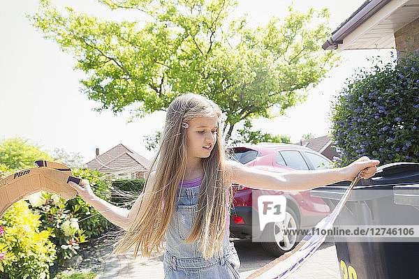 Girl recycling in driveway