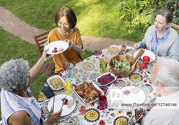 Senior friends enjoying lunch at patio table