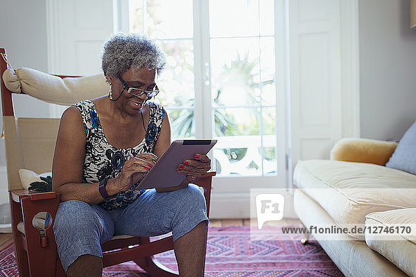 Senior woman using digital tablet in living room