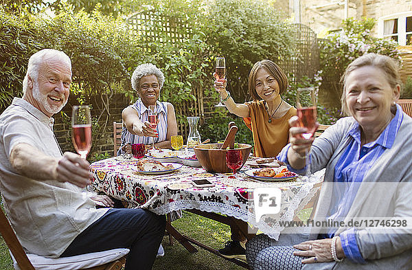 Portrait smiling  confident active senior friends drinking rose wine and enjoying lunch at patio table