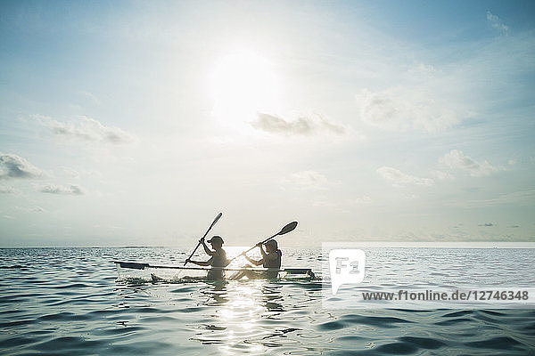 Women in clear bottom canoe on sunny  idyllic ocean  Maldives  Indian Ocean