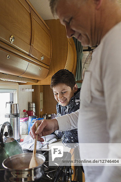 Father and son cooking in motor home