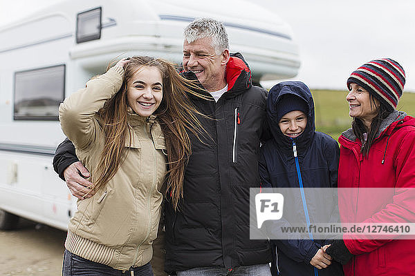 Portrait happy family in warm clothing outside motor home