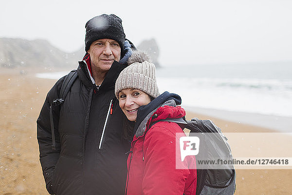 Portrait couple in warm clothing on winter beach