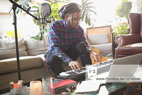 Junger Mann nimmt Musik auf und spielt Klavier in einer Wohnung