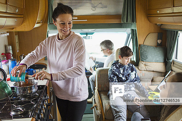 Happy family cooking and relaxing in motor home