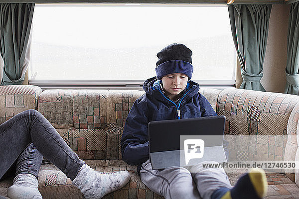 Jugendlicher benutzt digitales Tablet im Wohnmobil