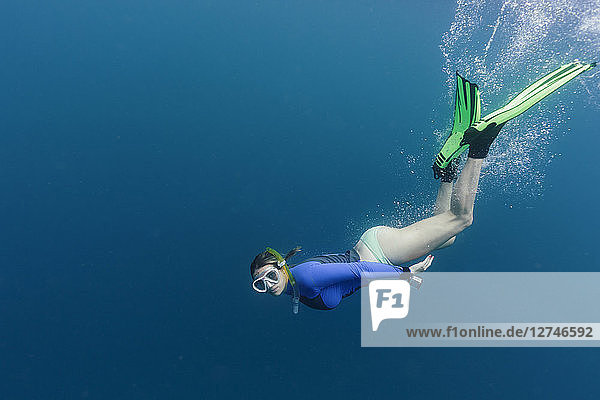 Portrait young woman snorkeling underwater
