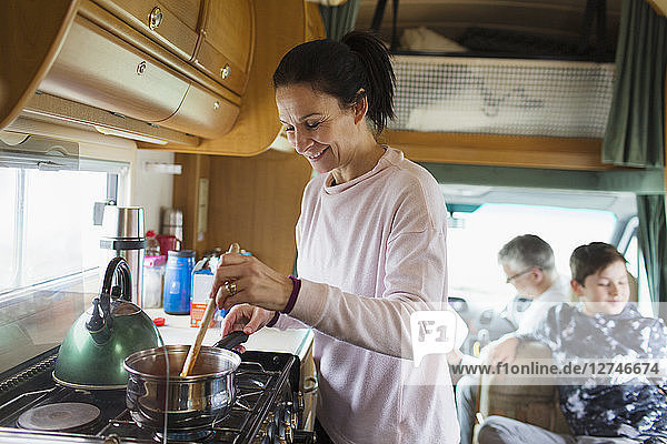 Smiling woman cooking in motor home