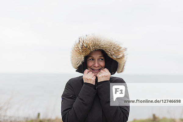 Portrait smiling woman in coat with fur hood