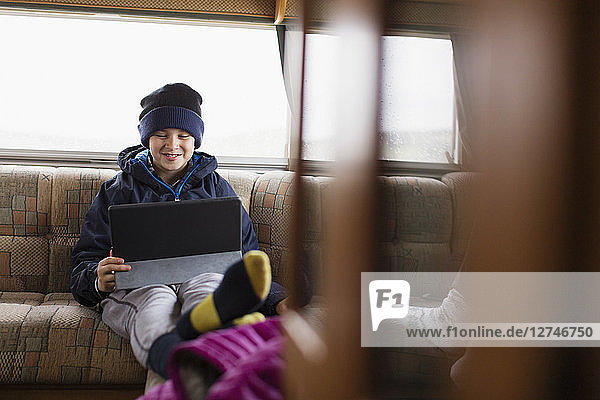 Jugendlicher benutzt digitales Tablet im Wohnmobil