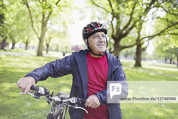 Active senior man riding bike in park