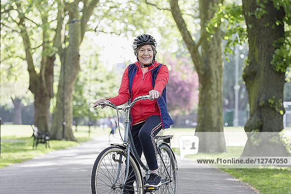 Portrait confident active senior woman riding bike in park