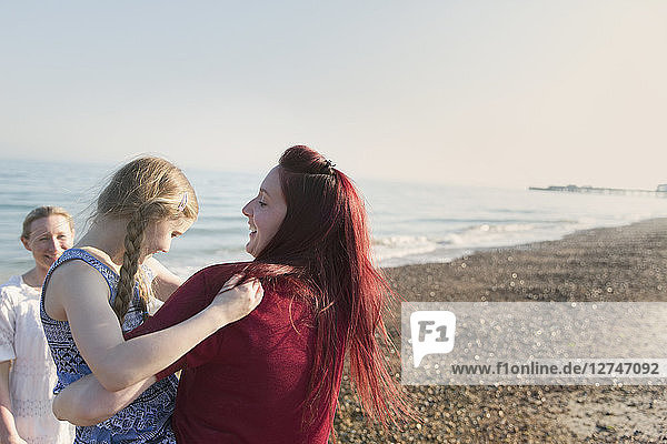 Lesbian couple and daughter on sunny beach
