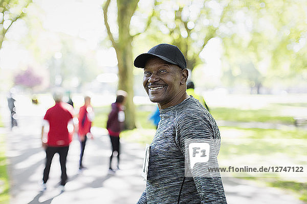 Portrait confident  happy senior man walking sports race in park