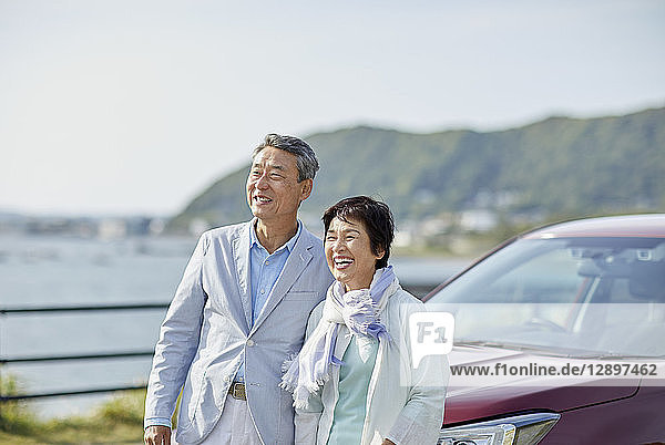 Japanisches Seniorenpaar amüsiert sich am Meer