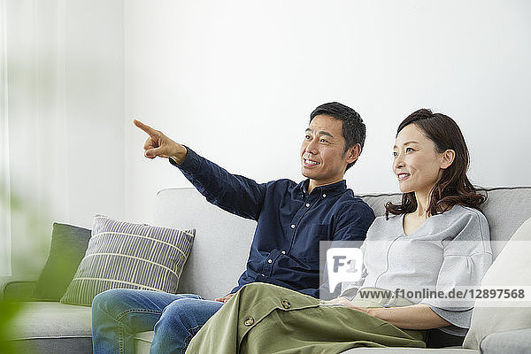 Japanisches reifes Paar auf dem Sofa