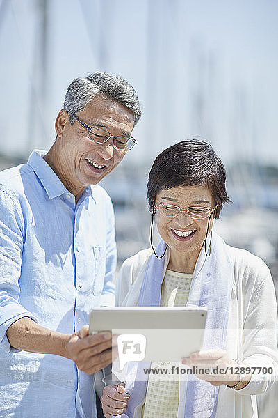 Japanisches Seniorenpaar amüsiert sich am Meer