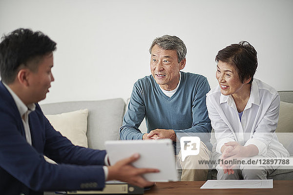 Japanese senior couple talking with consultant