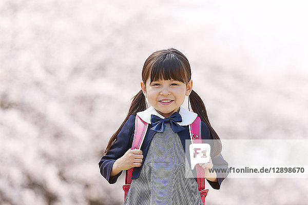 Japanische Grundschülerin und Kirschblüten