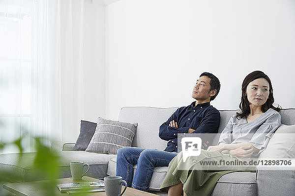 Japanisches reifes Paar auf dem Sofa