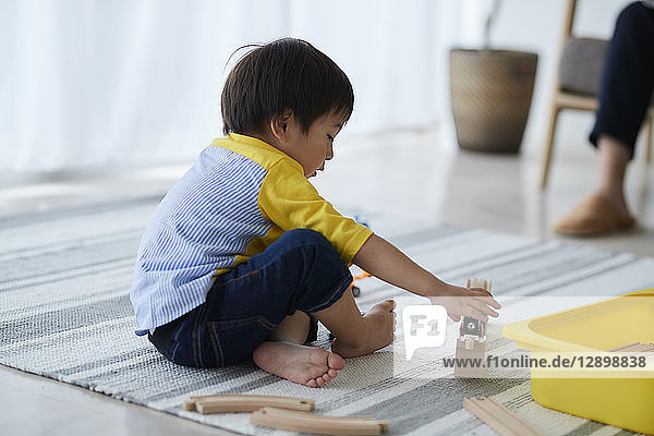 Japanisches Kind spielt im Wohnzimmer