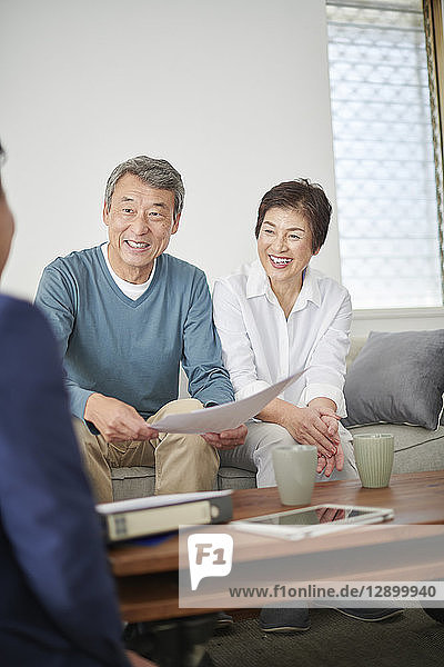 Japanese senior couple talking with consultant