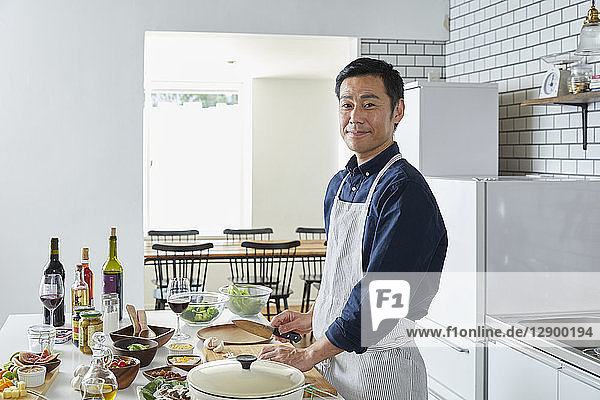 Japanischer reifer Mann in der Küche