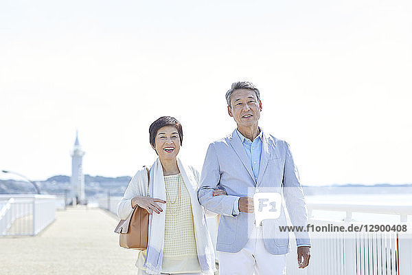 Japanisches Seniorenpaar amüsiert sich am Meer