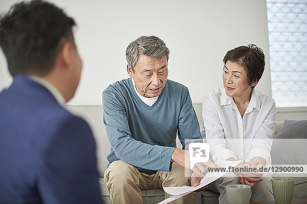 Japanese senior couple talking with consultant